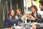 Varios jóvenes disfrutando con una copa de vino